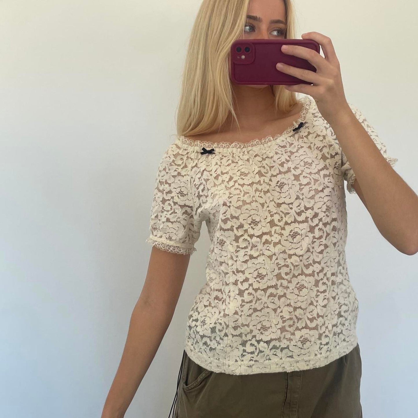 Cream lace off shoulder top with black bow detail, versatile