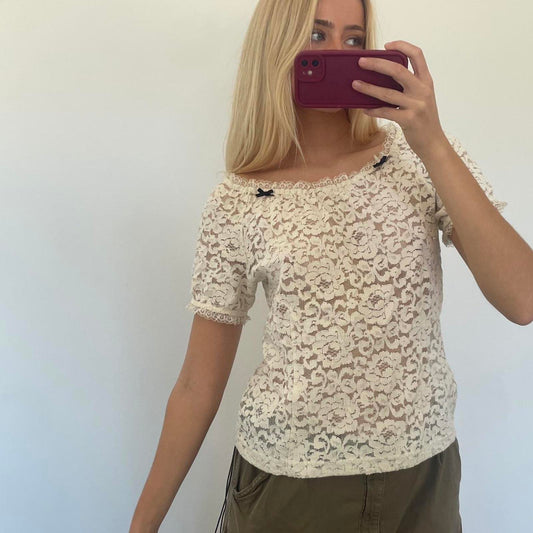 Cream lace off shoulder top with black bow detail, versatile